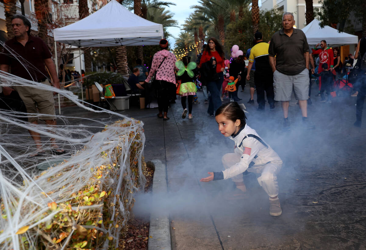 Jenna Epler-Day, 4, pretends to launch into space during the Halloween Ghost Walk at The Distri ...