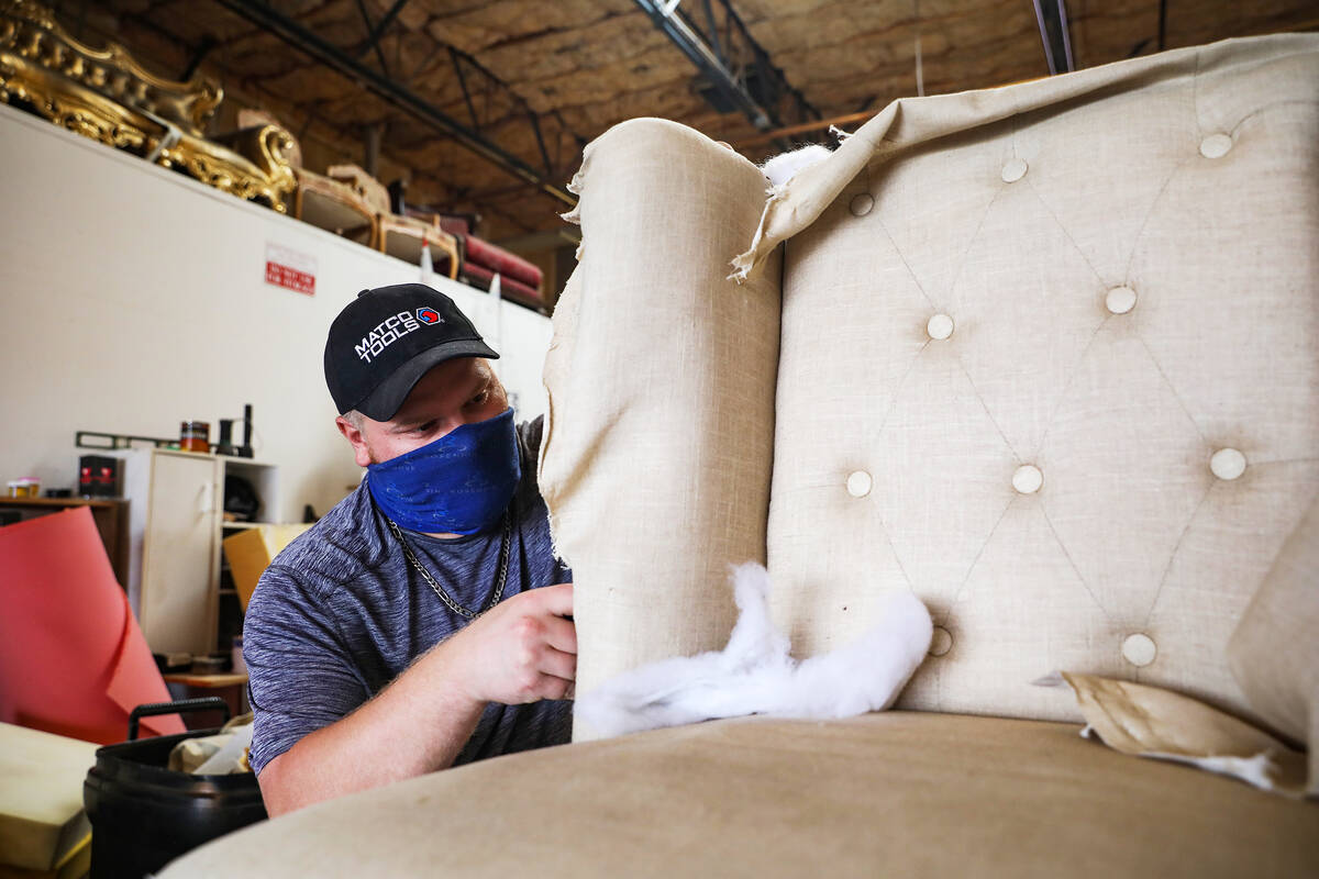 Apprentice Kris Vsetecka tears down a chair to be reupholstered at Summerlin Upholstery in Las ...