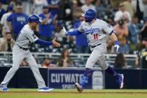 Los Angeles Dodgers' AJ Pollock, right, reacts with third base coach Dino Ebel after hitting a ...