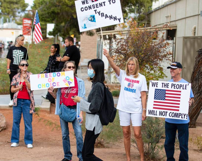 A UNLV student walks past Janice Brosmr, second left, Julie Williams and her husband Terry, all ...