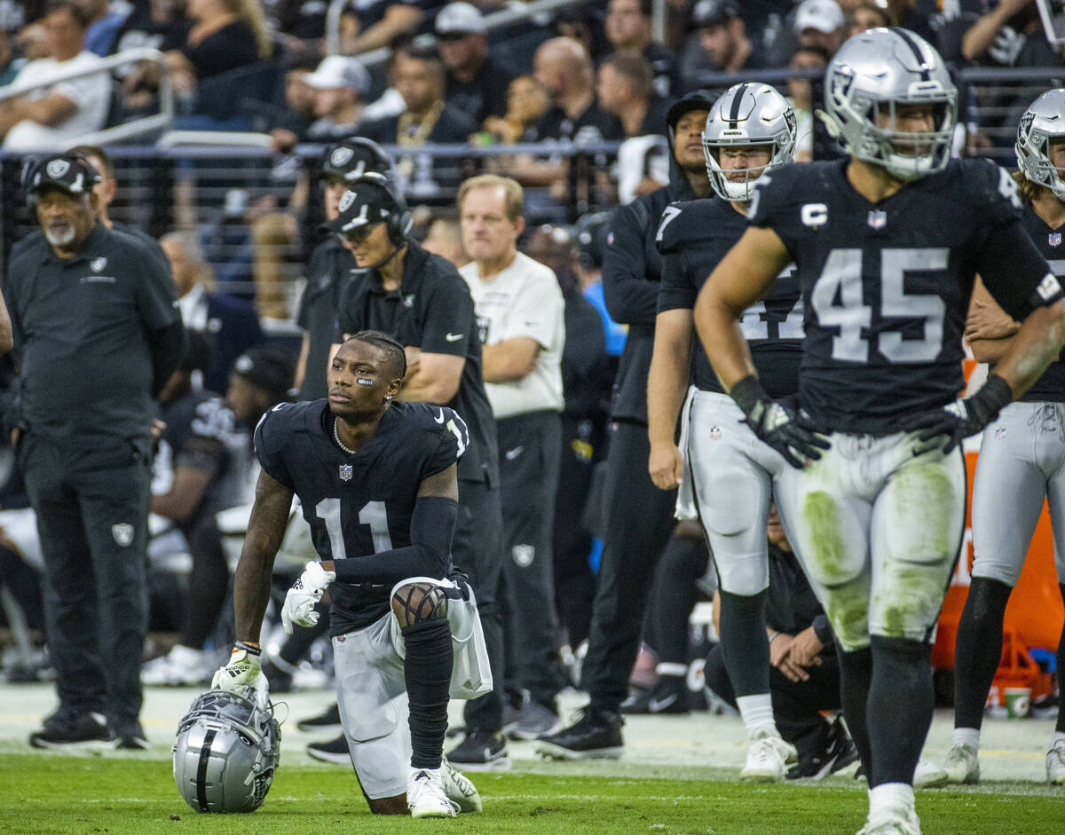Raiders wide receiver Henry Ruggs III (11) takes a knee as a player is injured on the field dur ...