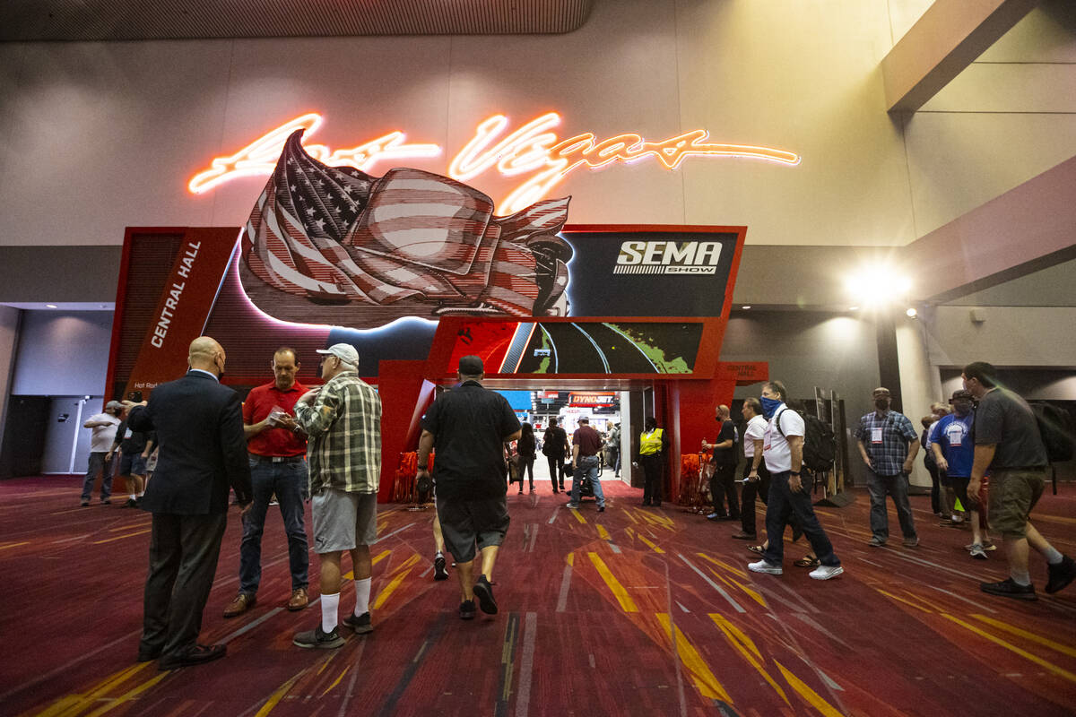 Attendees walk around outside of an exhibit hall during the Specialty Equipment Market Associat ...