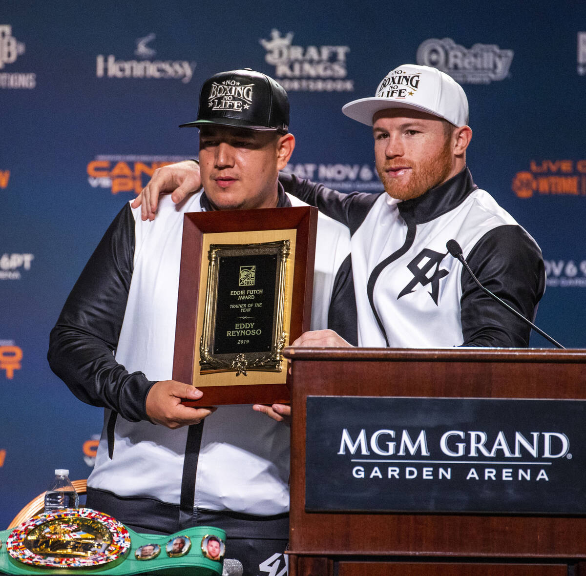 Trainer Eddy Reynoso is presented with a plaque by his boxer Canelo Alvarez for 2019 trainer of ...