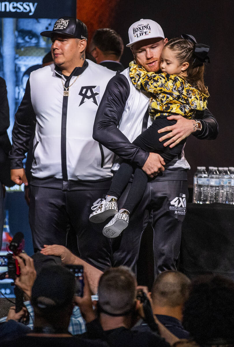 Boxer Canelo Alvarez holds his daughter Maria Fernanda Alvarez, 3, with trainer Eddy Reynoso st ...