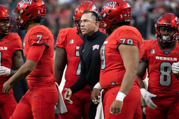 UNLV Rebels head coach Marcus Arroyo, middle, gives direction to his team during a time out in ...