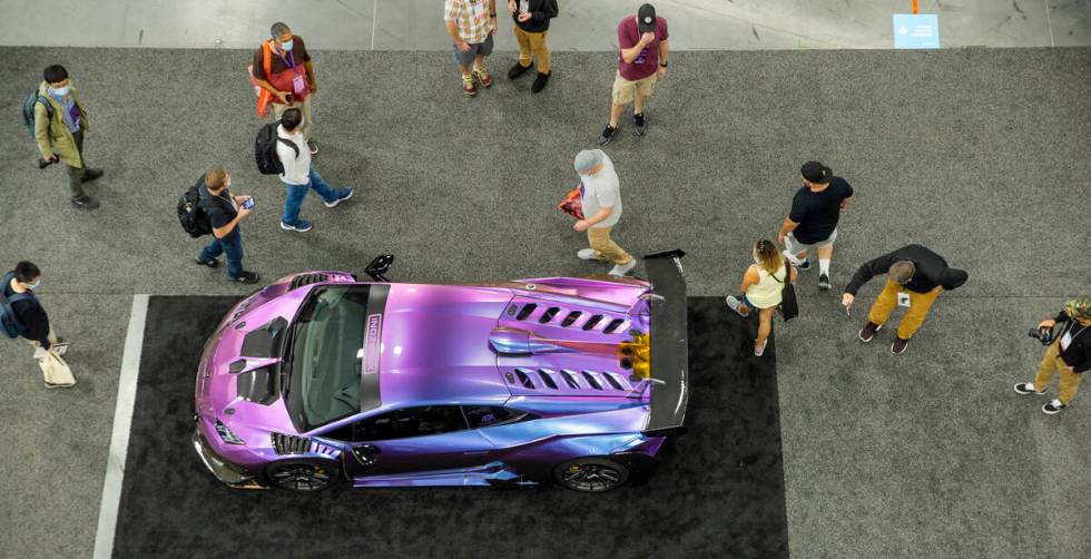 Attendees check out the a vehicle wrapped by Inozetek on display in the West Hall during SEMA a ...