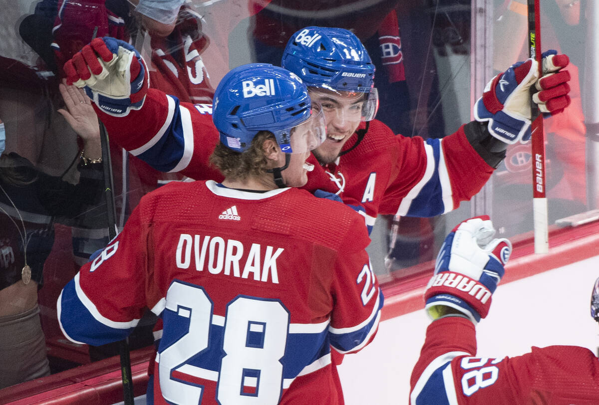 Montreal Canadiens' Nick Suzuki (14) celebrates with teammate Christian Dvorak after scoring ag ...