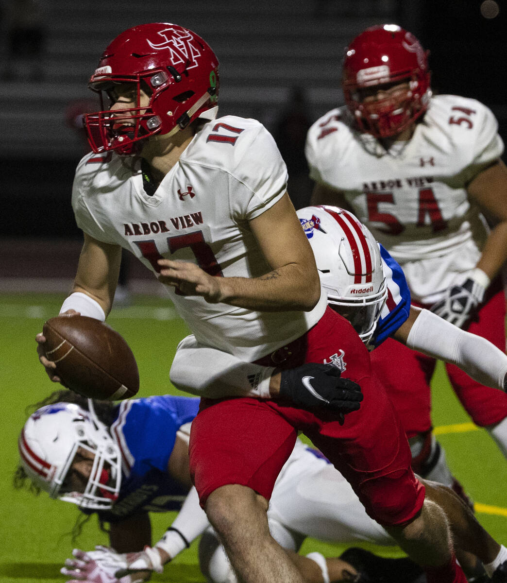 Arbor View High quarterback Kyle Holmes (17) tackled by Liberty High defensive end Anthony Jone ...