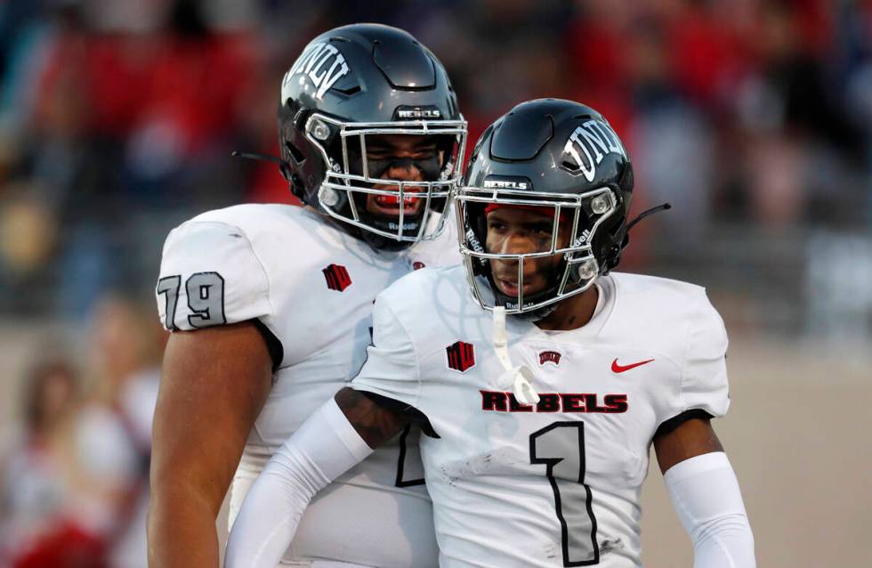 UNLV wide receiver Kyle Williams (1) is congratulated by offensive lineman Leif Fautanu (79) af ...