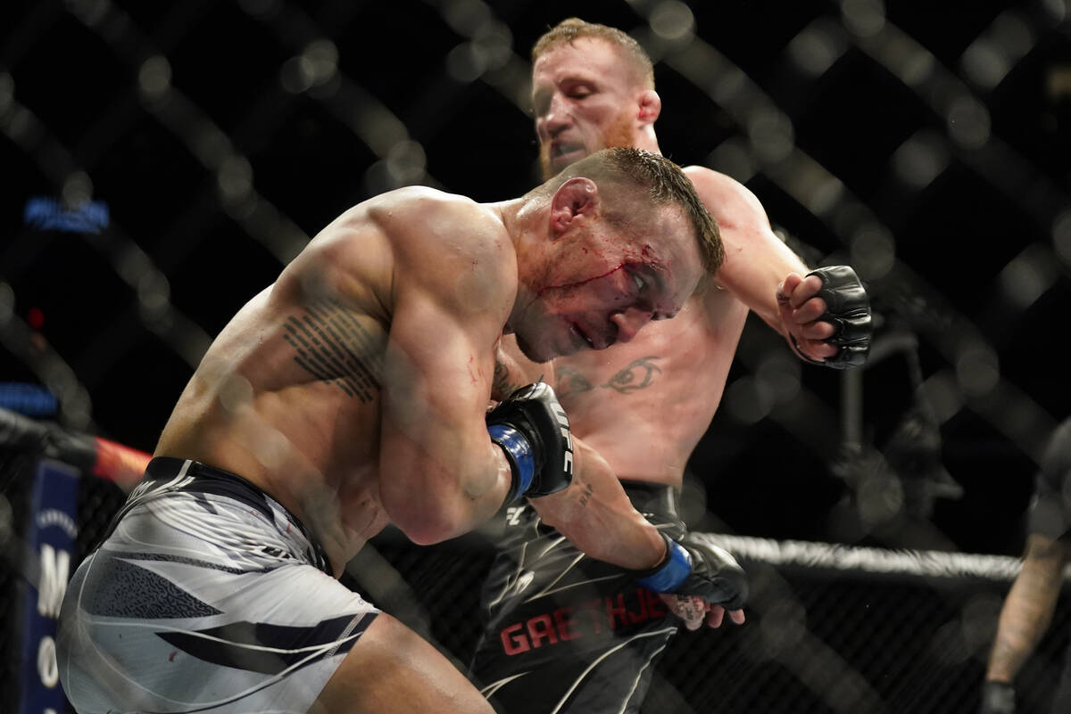 Michael Chandler, left, exchanges punches with Justin Gaethje during a lightweight mixed martia ...