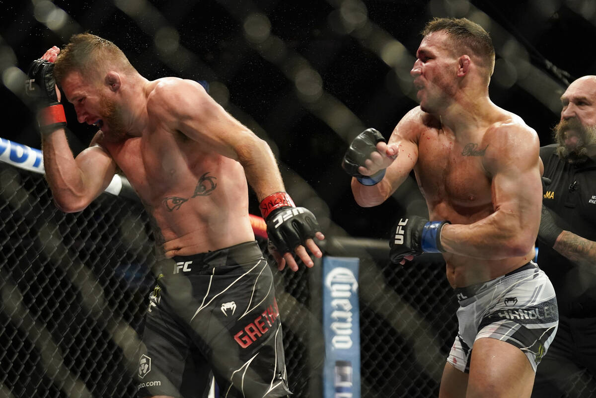 Justin Gaethje, left, reacts to a punch from Michael Chandler during a lightweight mixed martia ...