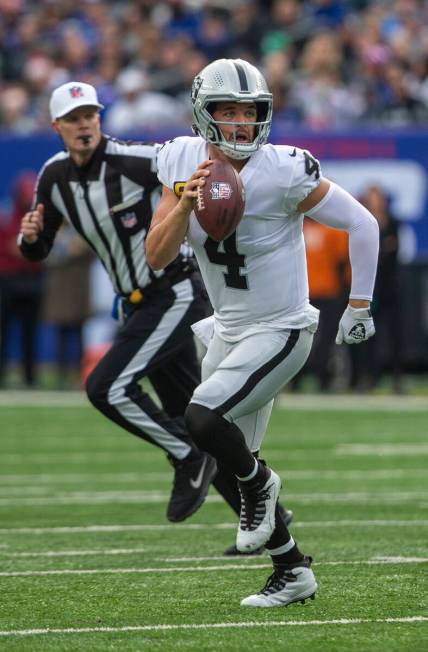 Las Vegas Raiders quarterback Derek Carr (4) looks for an open receiver as he is flushed out of ...