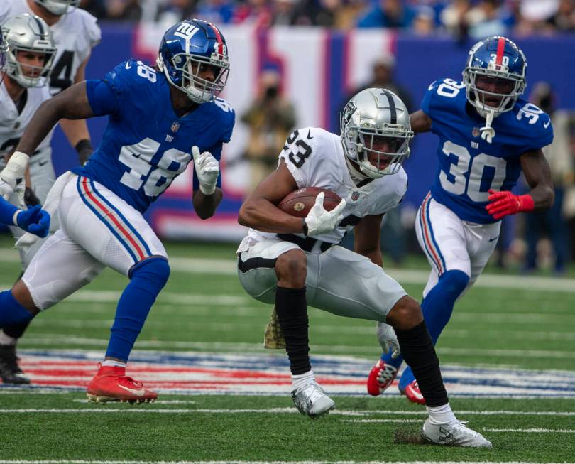 Las Vegas Raiders running back Kenyan Drake (23) looks for running room as New York Giants line ...