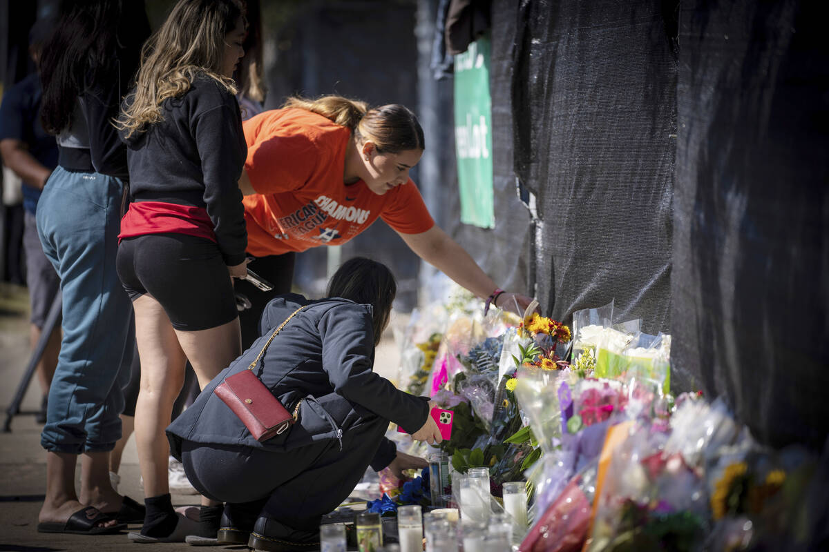 Stacey Sarmiento places flowers at a memorial in Houston on Sunday, Nov. 7, 2021 in memory of h ...