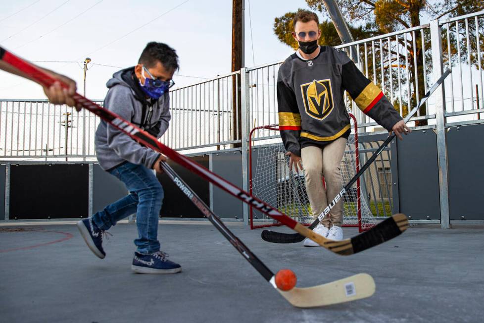 Newly acquired Golden Knights center Jack Eichel, right, defends the net against Alexander, 9, ...
