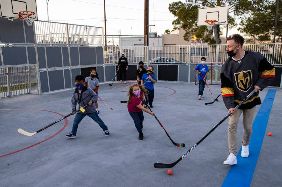 Newly acquired Golden Knights center Jack Eichel, right, plays with kids in a scrimmage match d ...