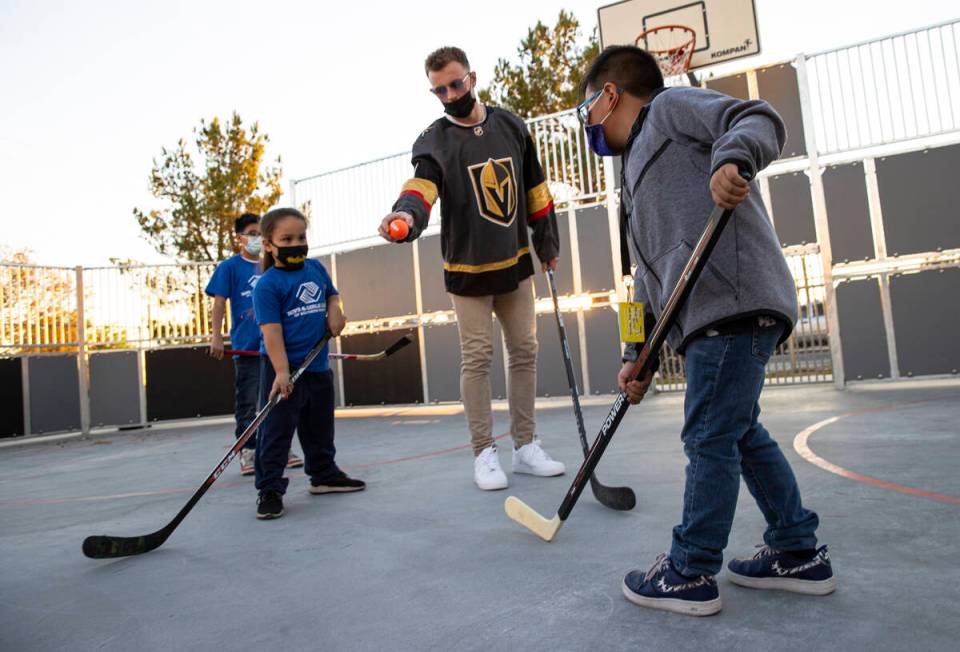 Newly acquired Golden Knights center Jack Eichel, center, prepares to drop the puck for face-of ...