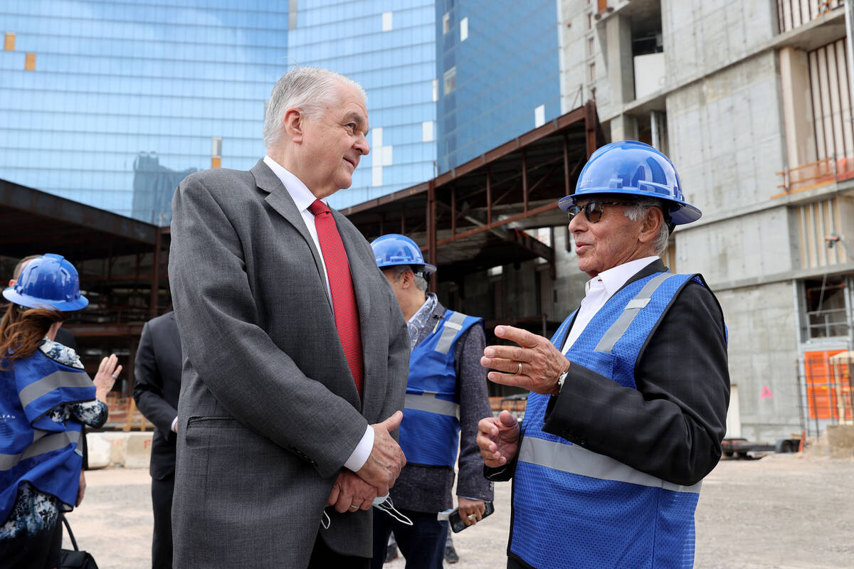 Gov. Steve Sisolak mingles with investor Joshua Saslove of Aspen, during a commencement ceremon ...