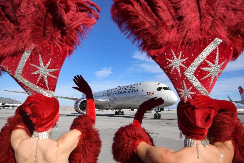 Showgirls wave as Virgin Atlantic Flight 155 from London Heathrow Airport arrives as the first ...