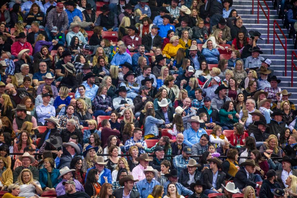 Fans greet their neighbors at the tenth go round of the Wrangler National Finals Rodeo at the T ...