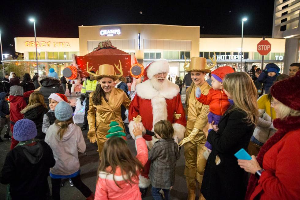 Santa is greeted by children as he walks down Festival Plaza Drive during the Downtown Summerli ...