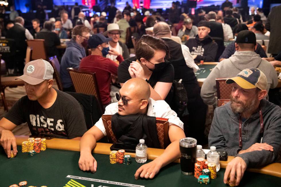 Players eye the dealer while one contender gets a massage during the World Series of Poker Main ...