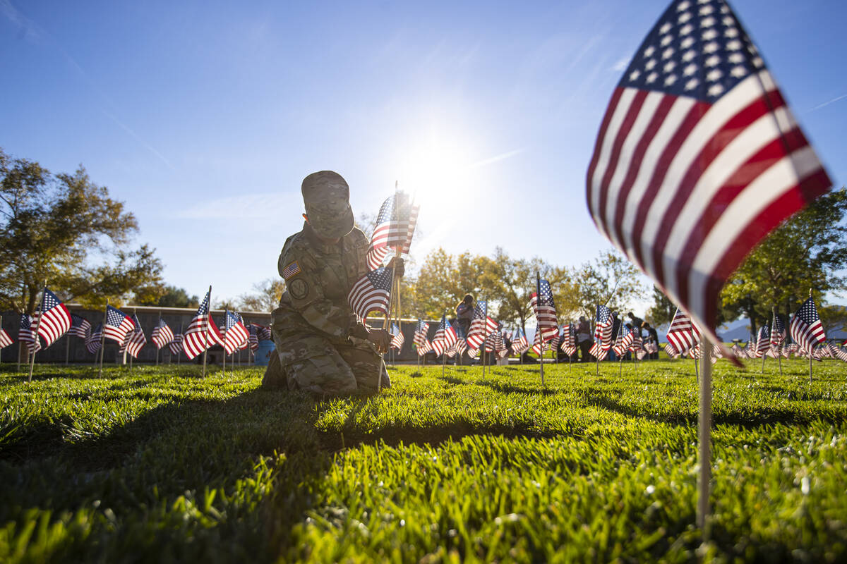 Nevada Army National Guard Sgt. Rosa Anaya places American flags on graves at the Southern Neva ...