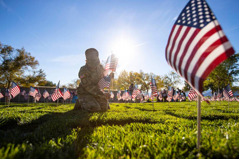 Nevada Army National Guard Sgt. Rosa Anaya places American flags on graves at the Southern Neva ...