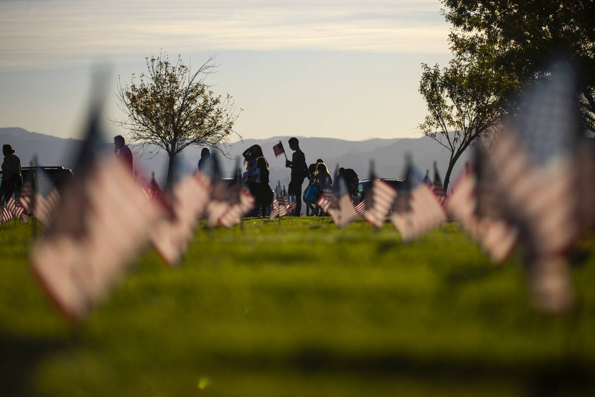 Volunteers place American flags on graves at the Southern Nevada Veterans Memorial Cemetery in ...