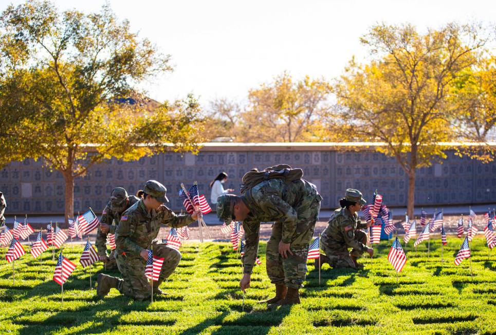 Nevada Army National Guard Sgt. April DiLiberto, left, and SFC John Foley place American flags ...