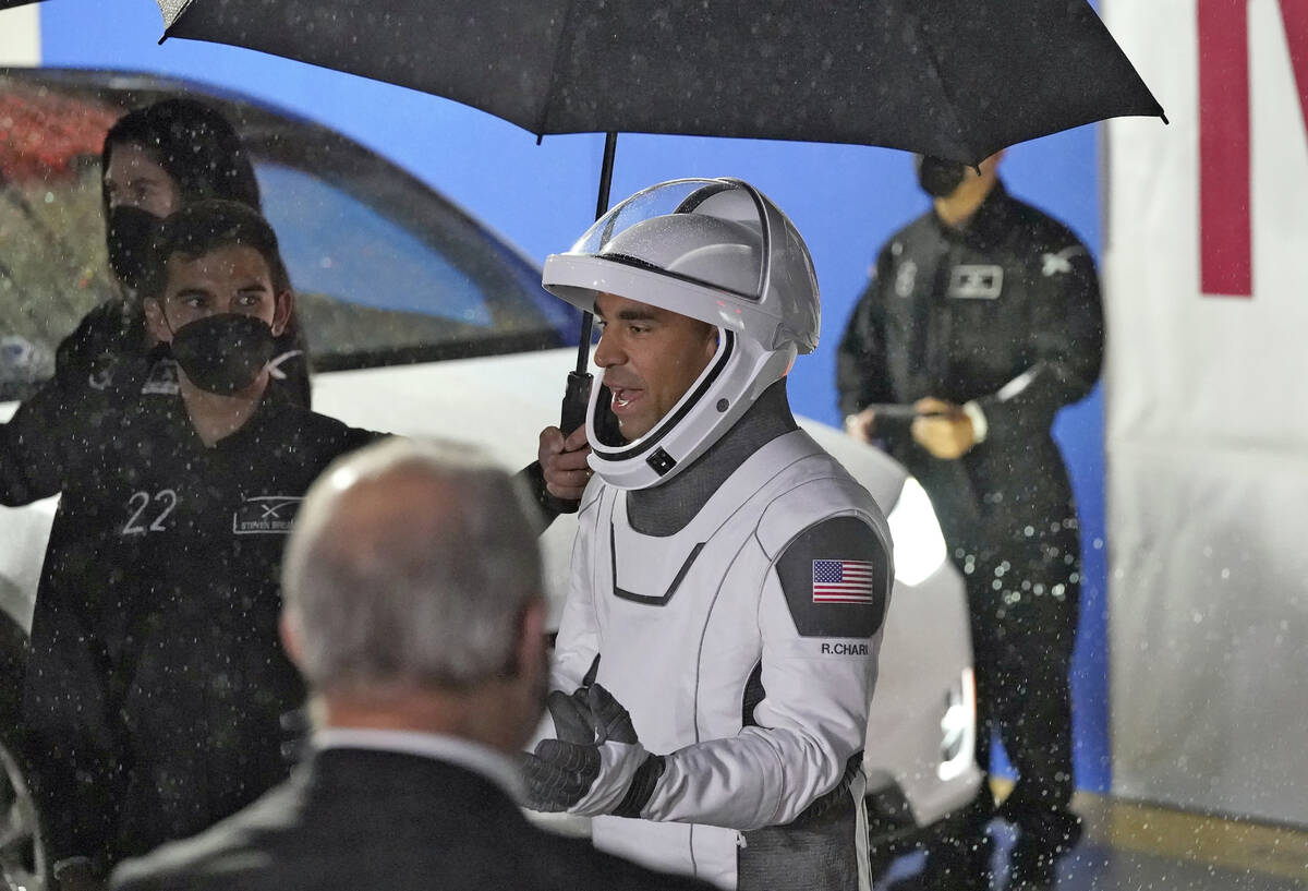 Astronaut Raja Chari stands under an umbrella as he talks to family members before heading to L ...