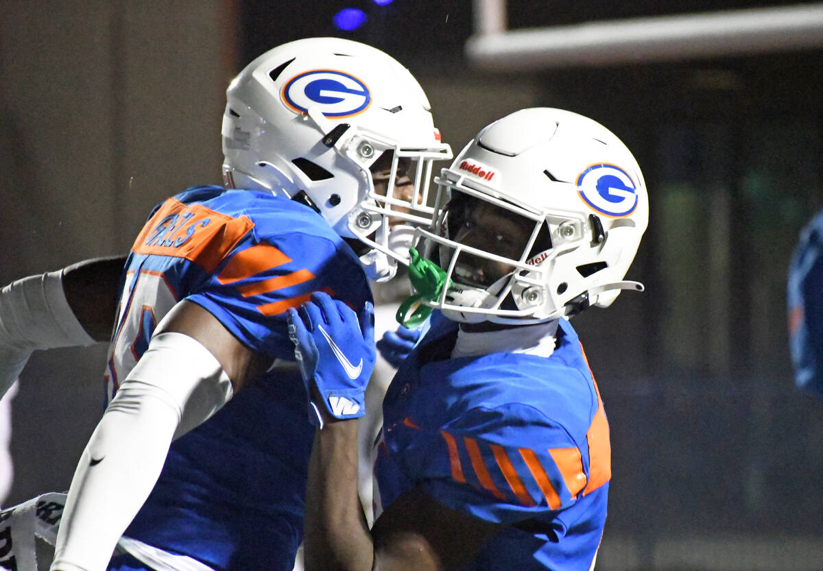 Bishop Gorman’s Jonathan Brady (right) celebrates a touchdown during a 5A region semifin ...