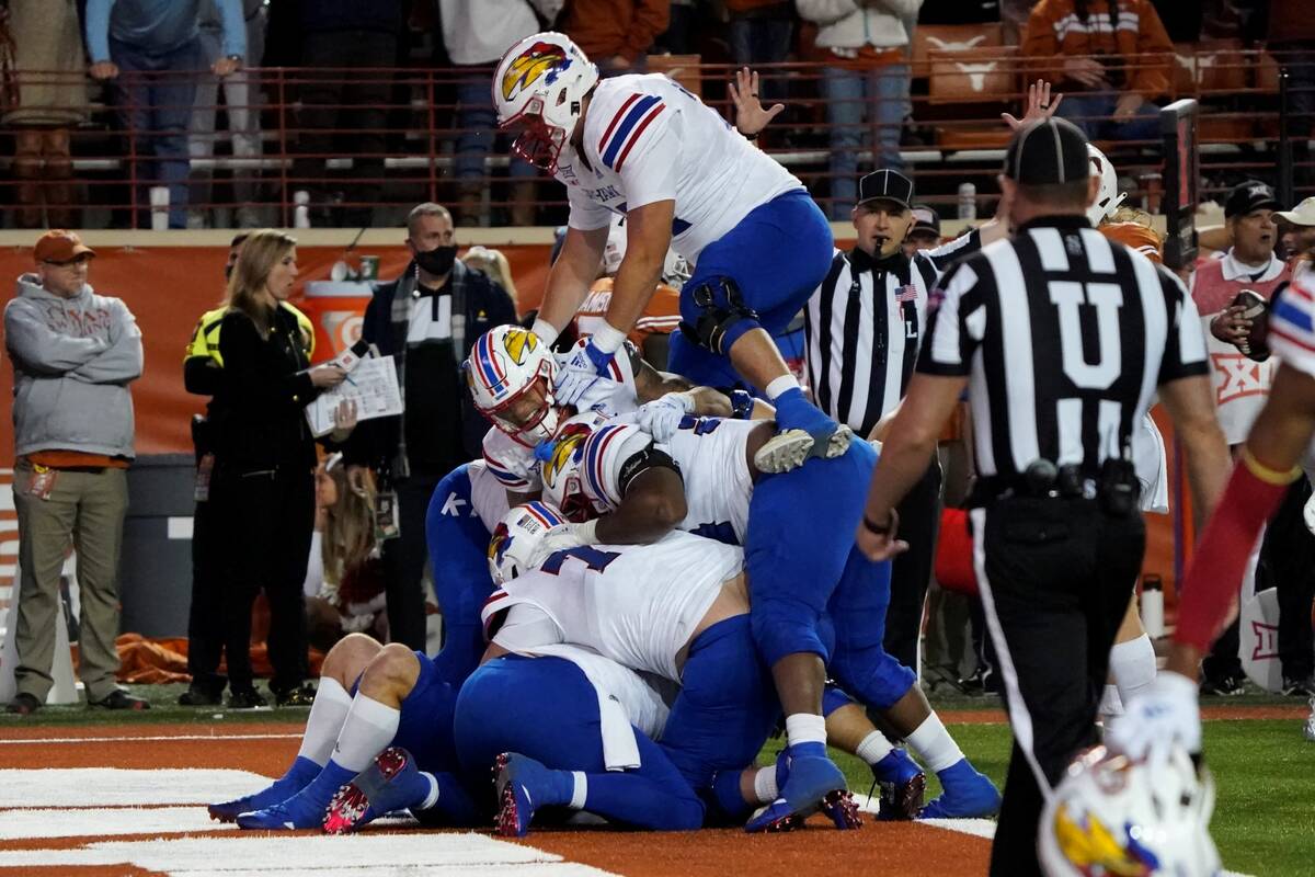 Kansas players celebrate their 57-56 win over Texas in overtime of an NCAA college football gam ...
