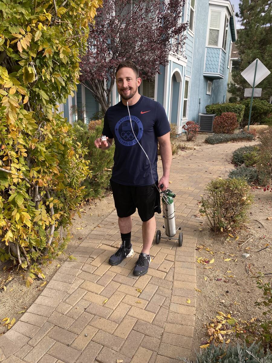 Matt Breslow checks his blood oxygen levels during a recent walk around his neighborhood. As he ...