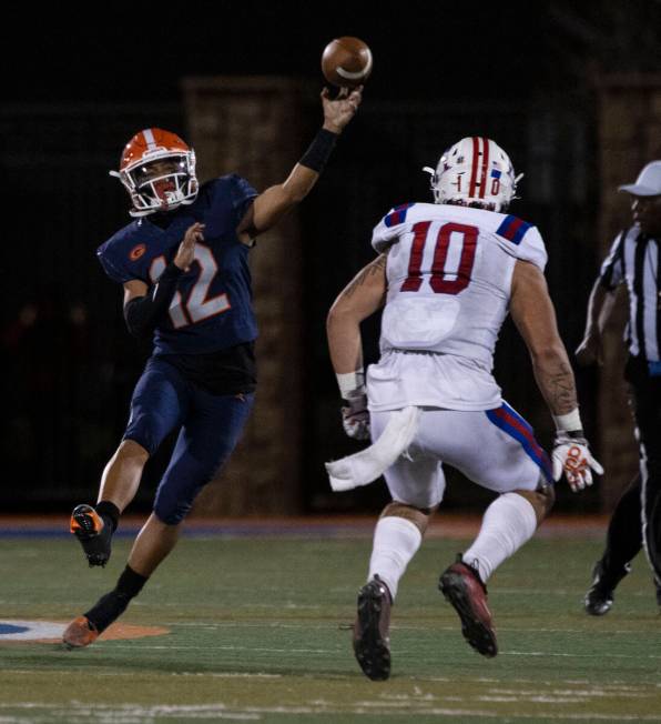 Bishop GormanÕs quarterback Micah Alejado (12) throws as LibertyÕs Cliffton Weber (1 ...