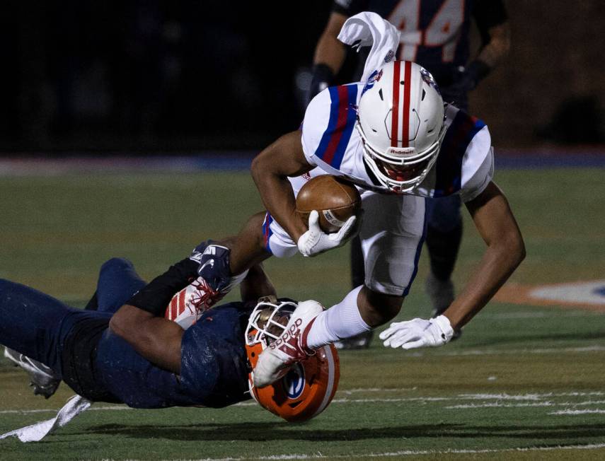 Bishop GormanÕs Jeremiah Hughes (13) tackles Liberty HighÕs Isaiah Hampton (15) durin ...