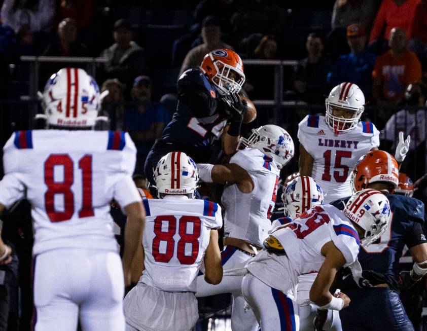 Bishop GormanÕs defensive back Kodi Decambra (24) sandwiched by Liberty High defenders as ...