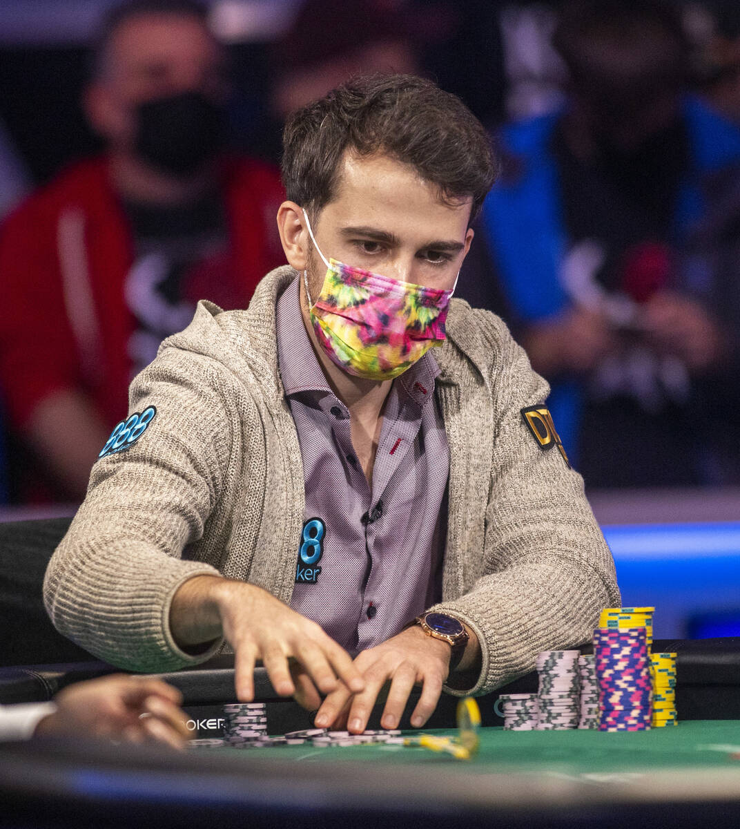 Koray Aldemir tosses chips in while facing George Holmes at the final table for the $10,000 buy ...