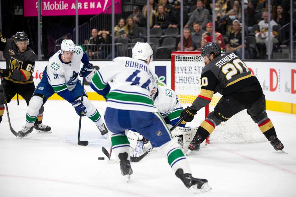 Golden Knights center Chandler Stephenson (20) passes to right wing Evgenii Dadonov (63) who sc ...