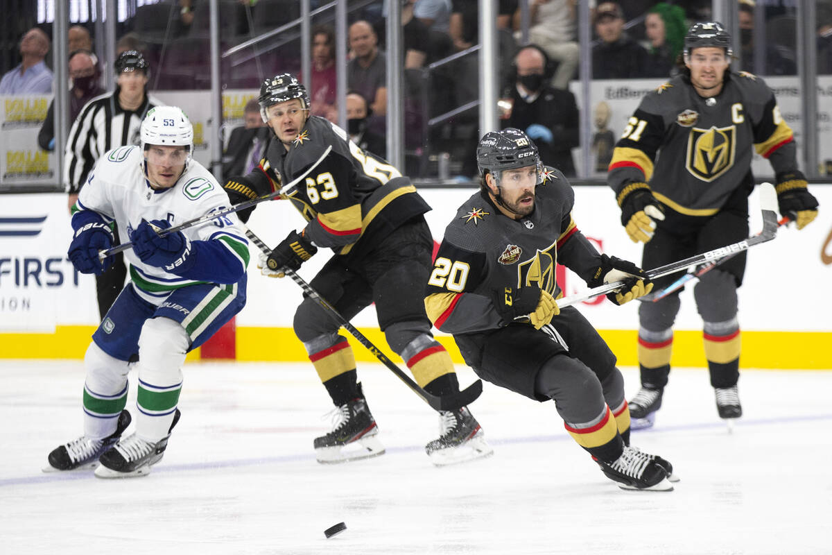 Golden Knights center Chandler Stephenson (20) looks to pass while Canucks center Bo Horvat (53 ...