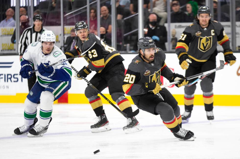 Golden Knights center Chandler Stephenson (20) looks to pass while Canucks center Bo Horvat (53 ...