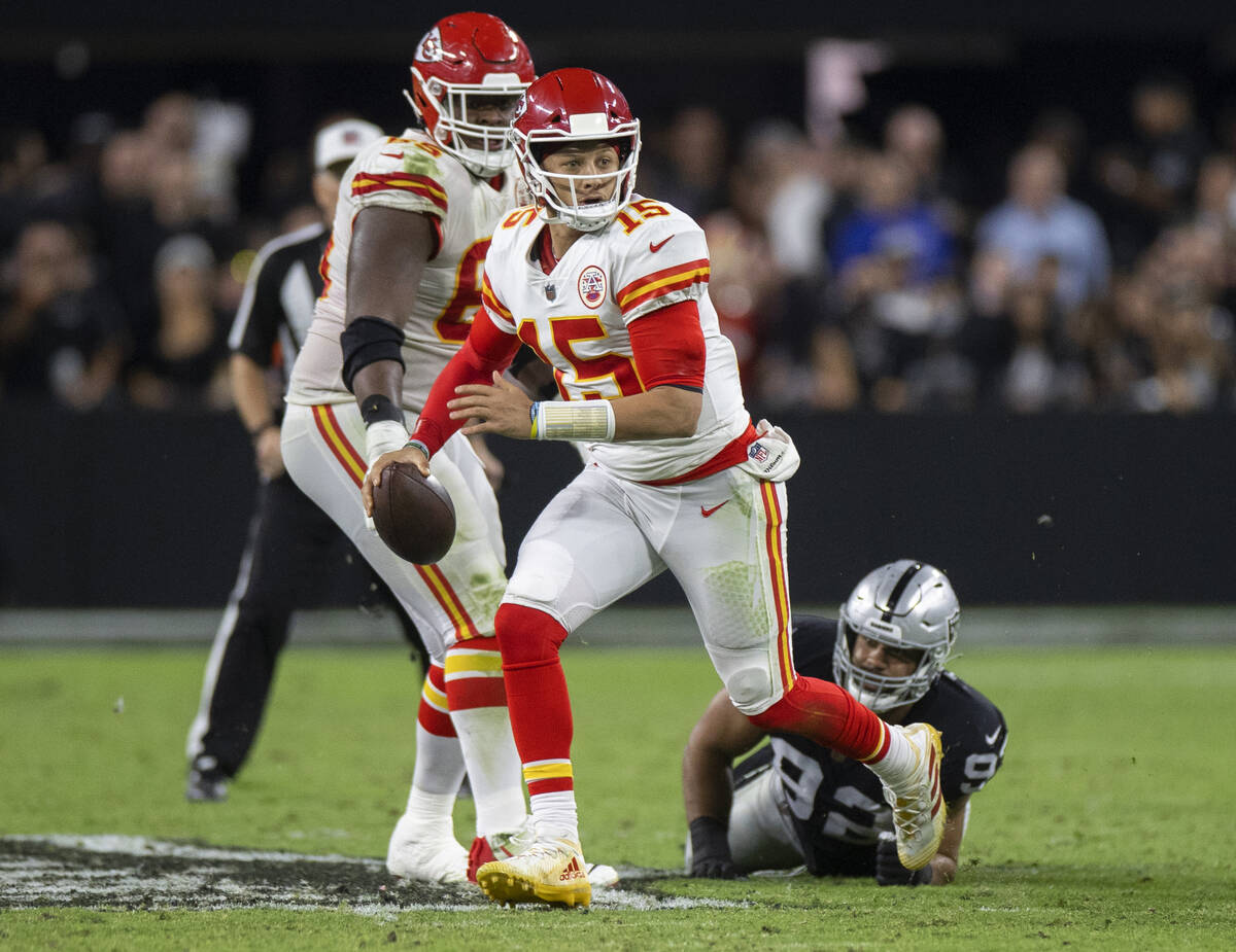 Kansas City Chiefs quarterback Patrick Mahomes (15) scrambles past Raiders defensive end Solomo ...