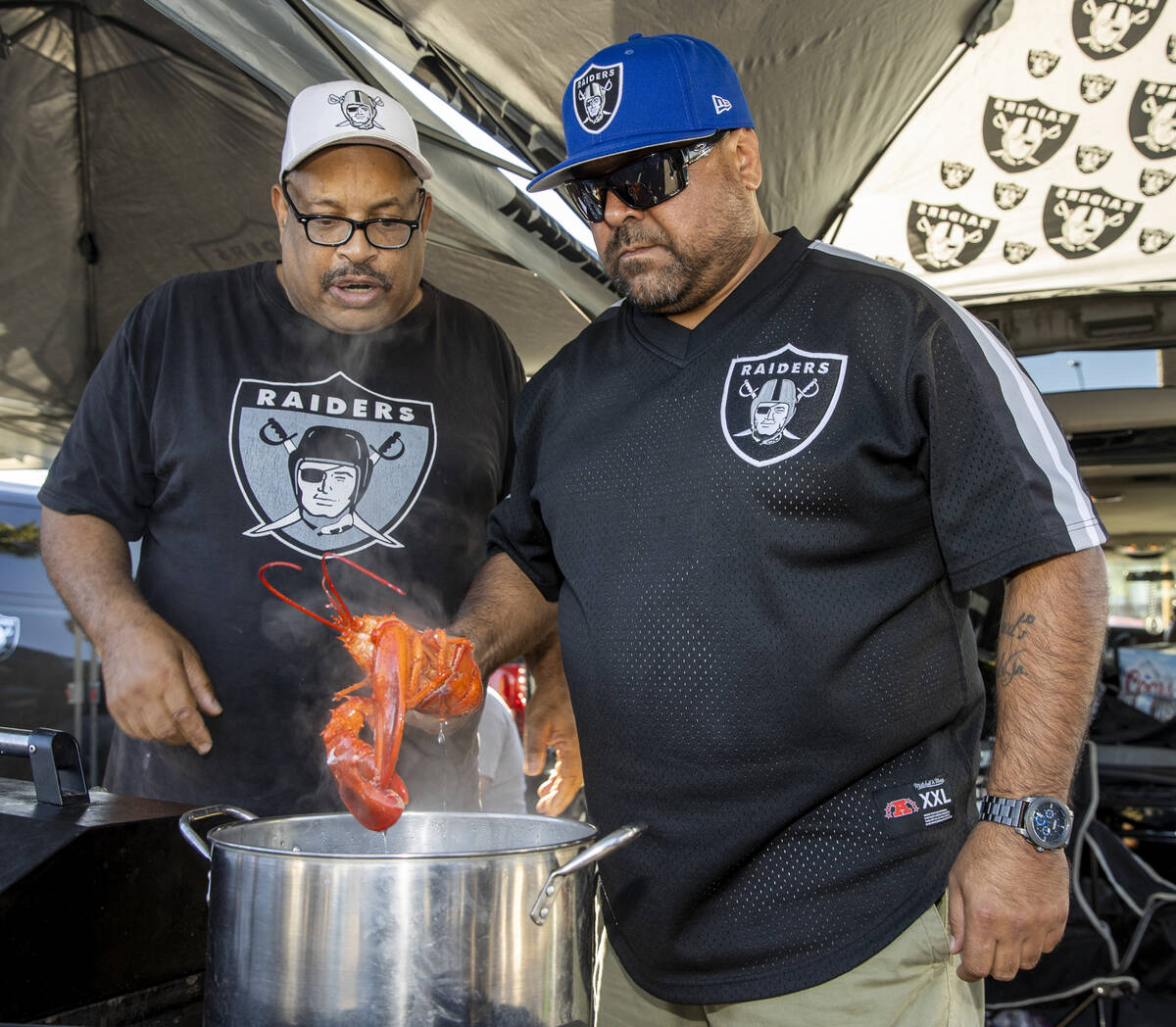 Raiders fans James Davidson, left, and Fernando Zarate of California check to see if one of the ...