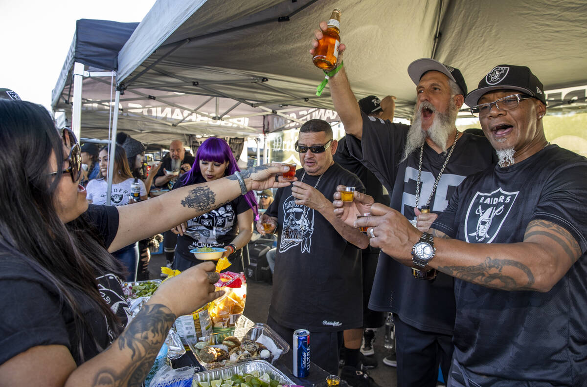 Raiders fans share shots in tailgating before an NFL game versus the Kansas City Chiefs at Alle ...