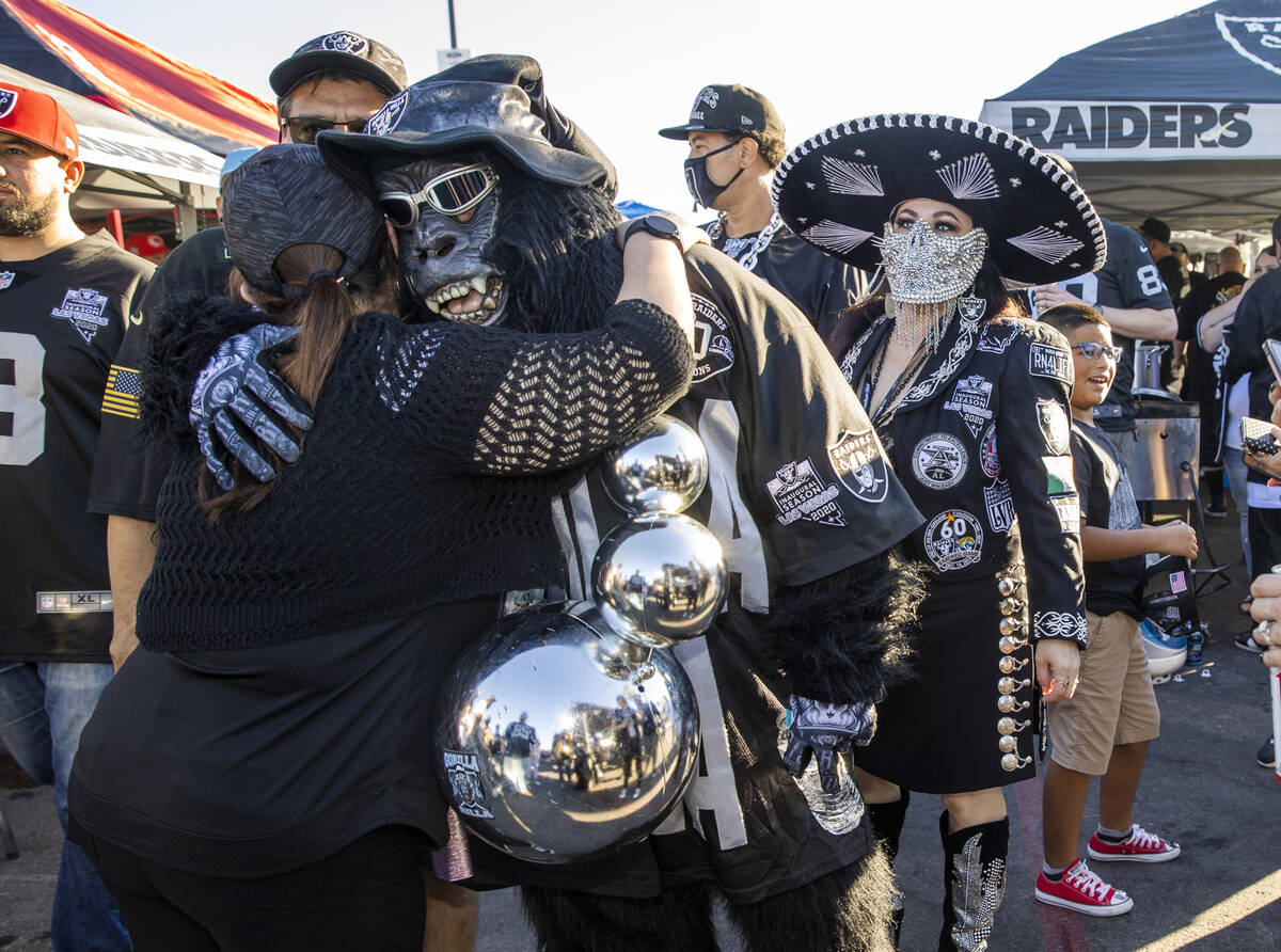 Raiders fans embrace in tailgating before an NFL game versus the Kansas City Chiefs at Allegian ...