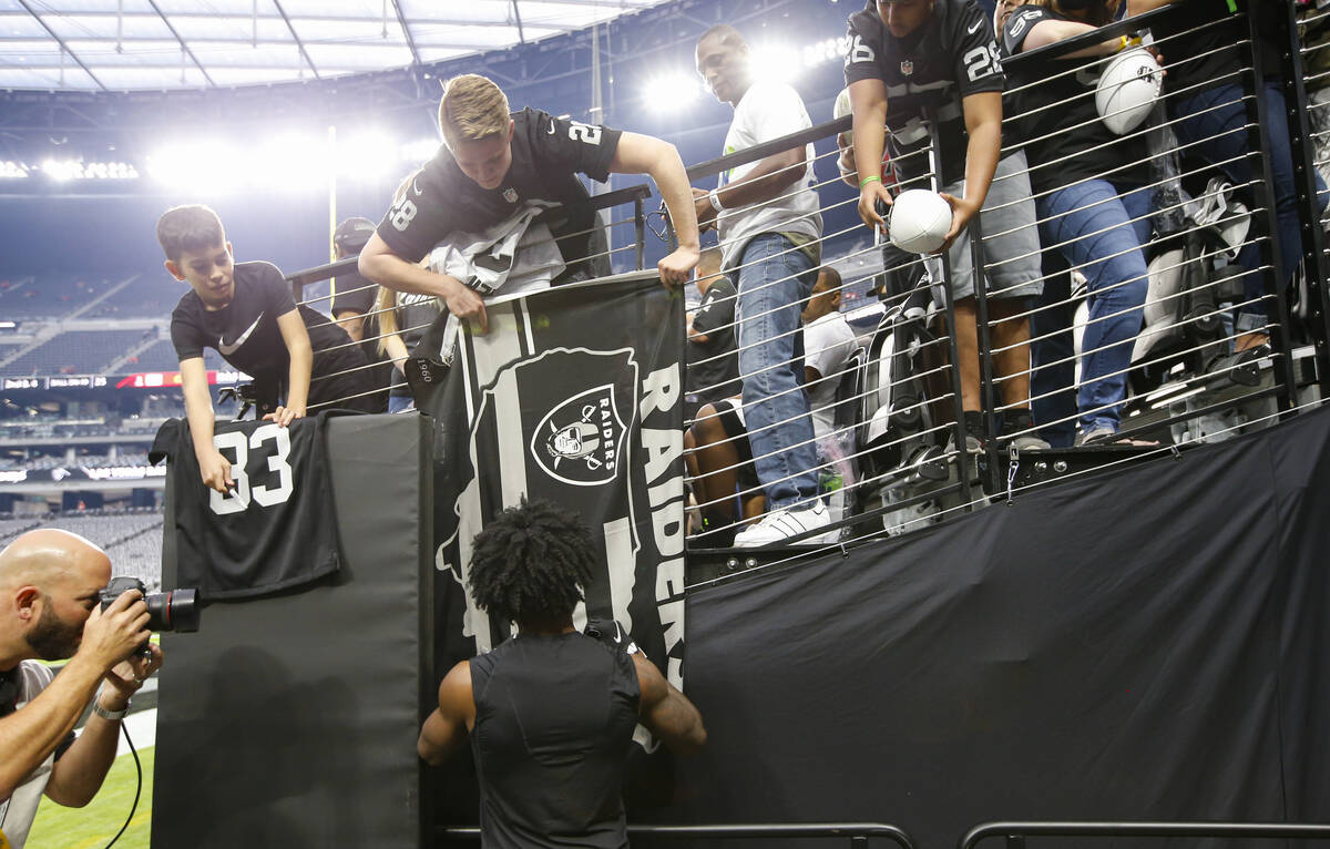 Las Vegas Raiders cornerback Nate Hobbs autographs items for fans before the start of an NFL ga ...
