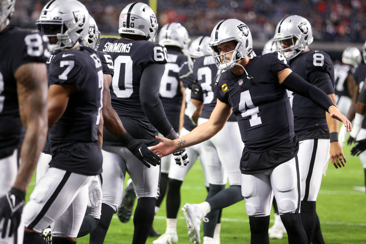 Raiders quarterback Derek Carr (4) welcomes players onto the field before the start of an NFL f ...