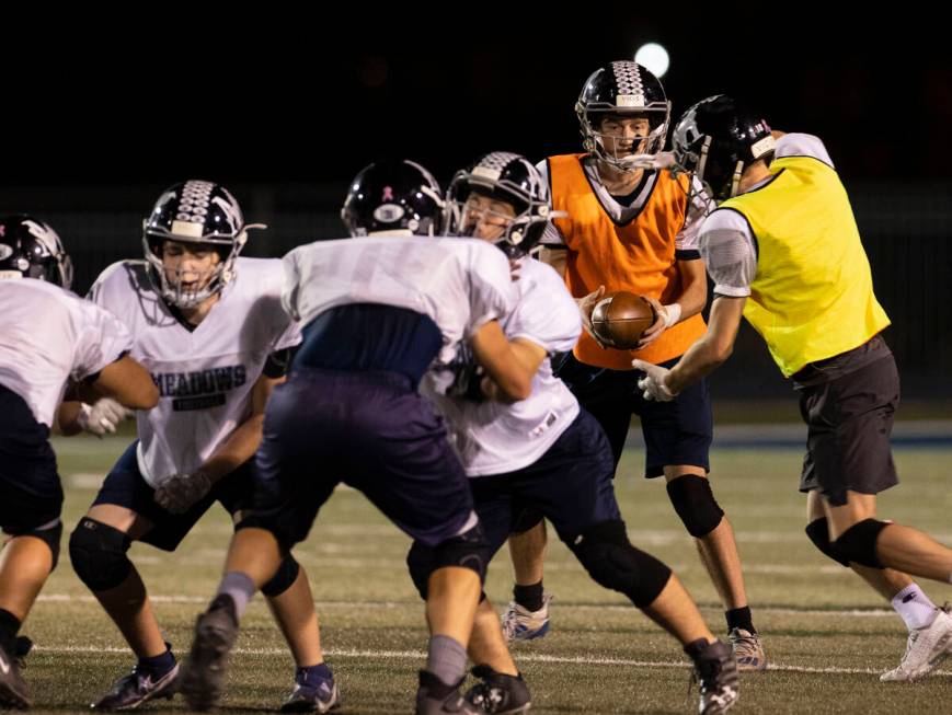 The Meadows High School quarterback Sean Gosse hands off the ball to John Mcgill, right, during ...