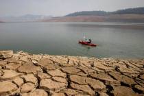 A kayaker fishes in Lake Oroville as water levels remain low due to continuing drought conditio ...