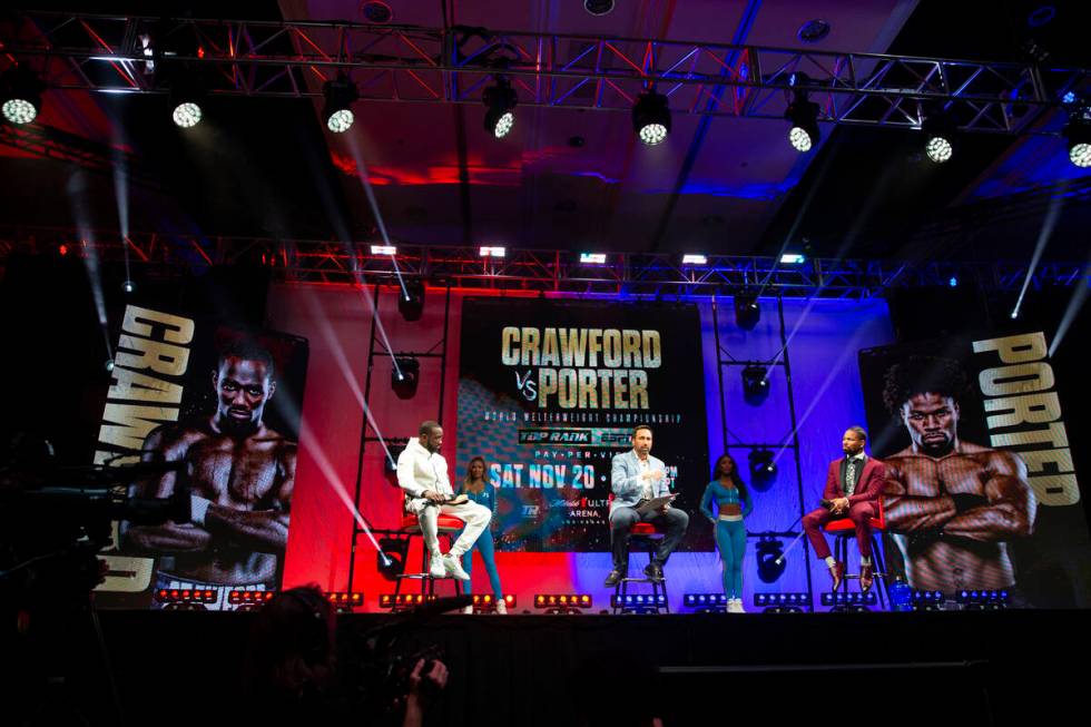 Boxers Terence Crawford, left, and Shawn Porter, right, with moderator Joe Tessitore, during ...